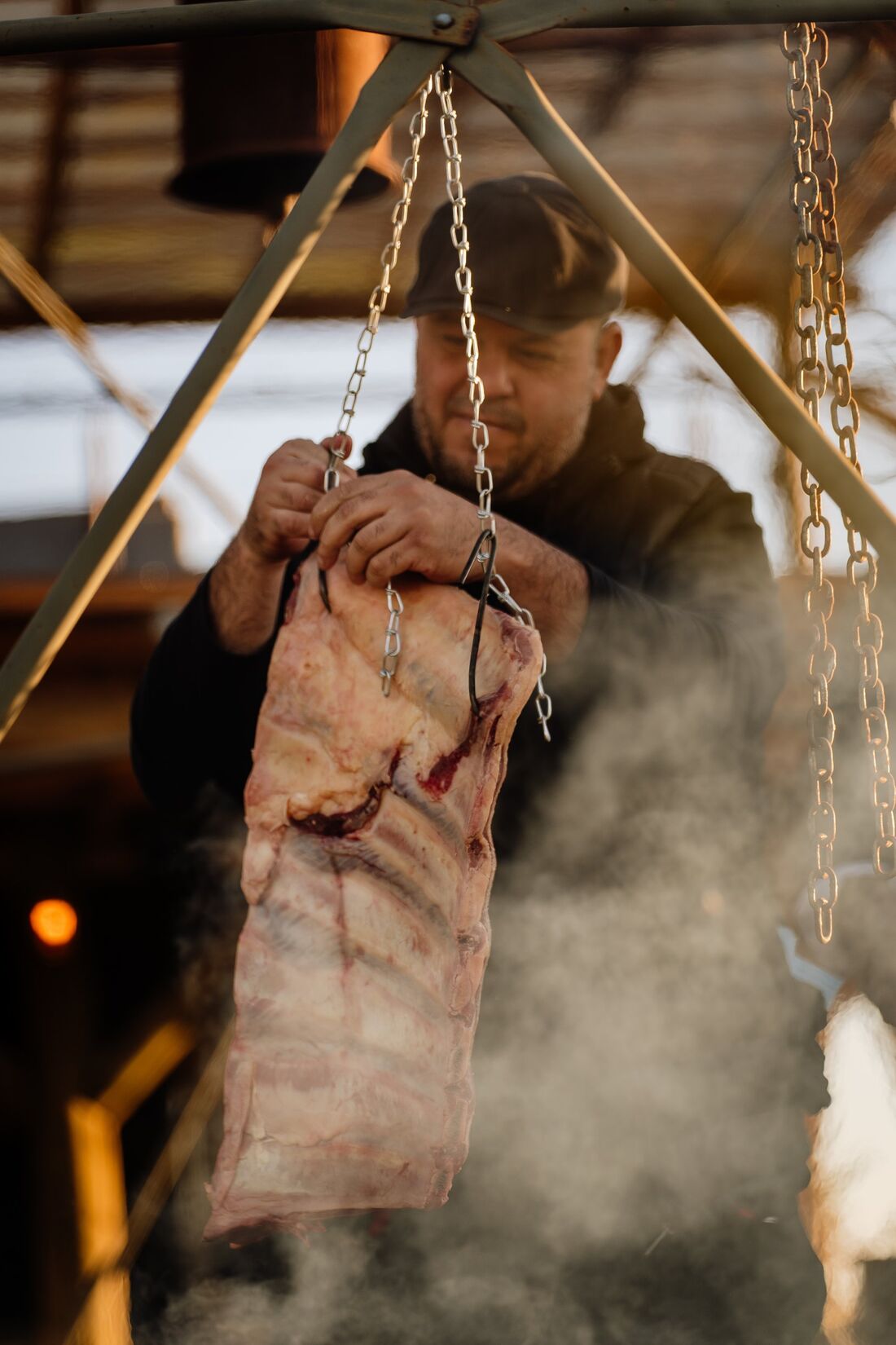 Chef Diego Fernando pendurando uma costela na parrilla